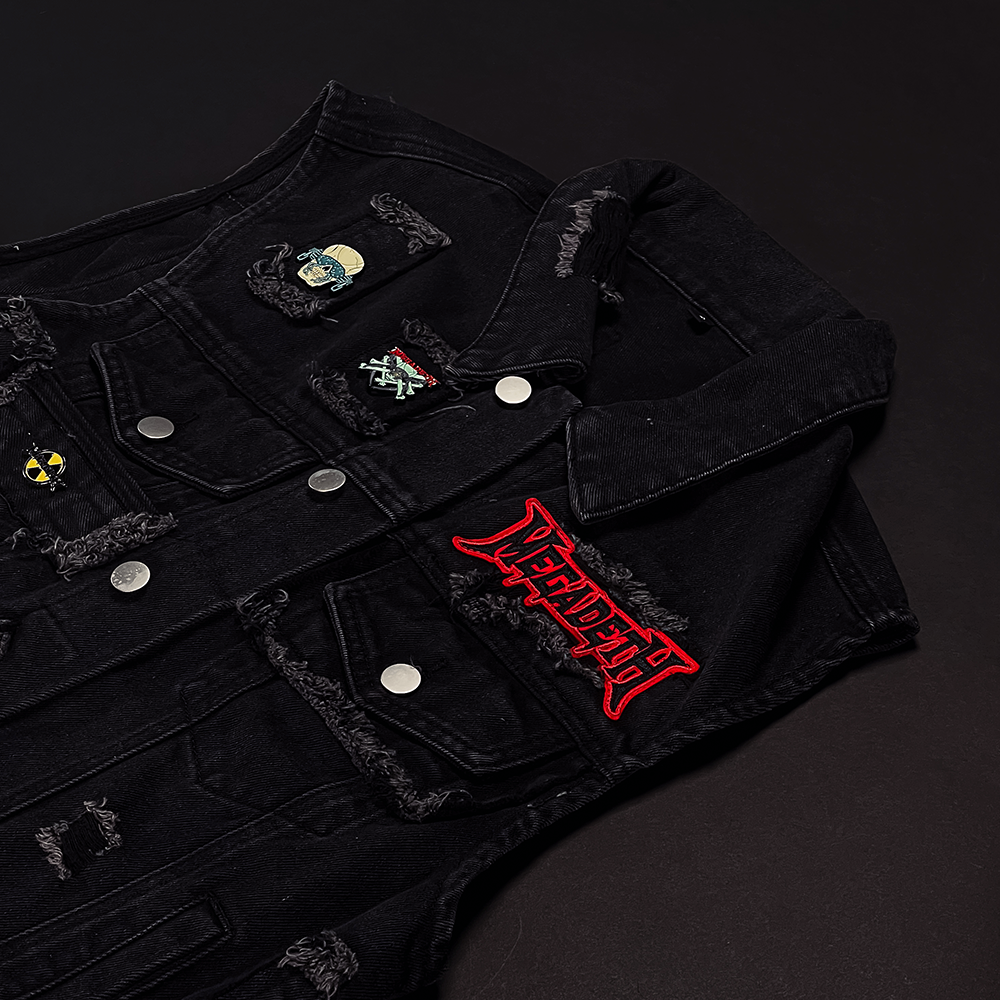 Official Megadeth Merchandise. Black button up denim vest with distressed details adorned with Megadeth pins and patches. The back features a large back patch with a silhouette of Vic.